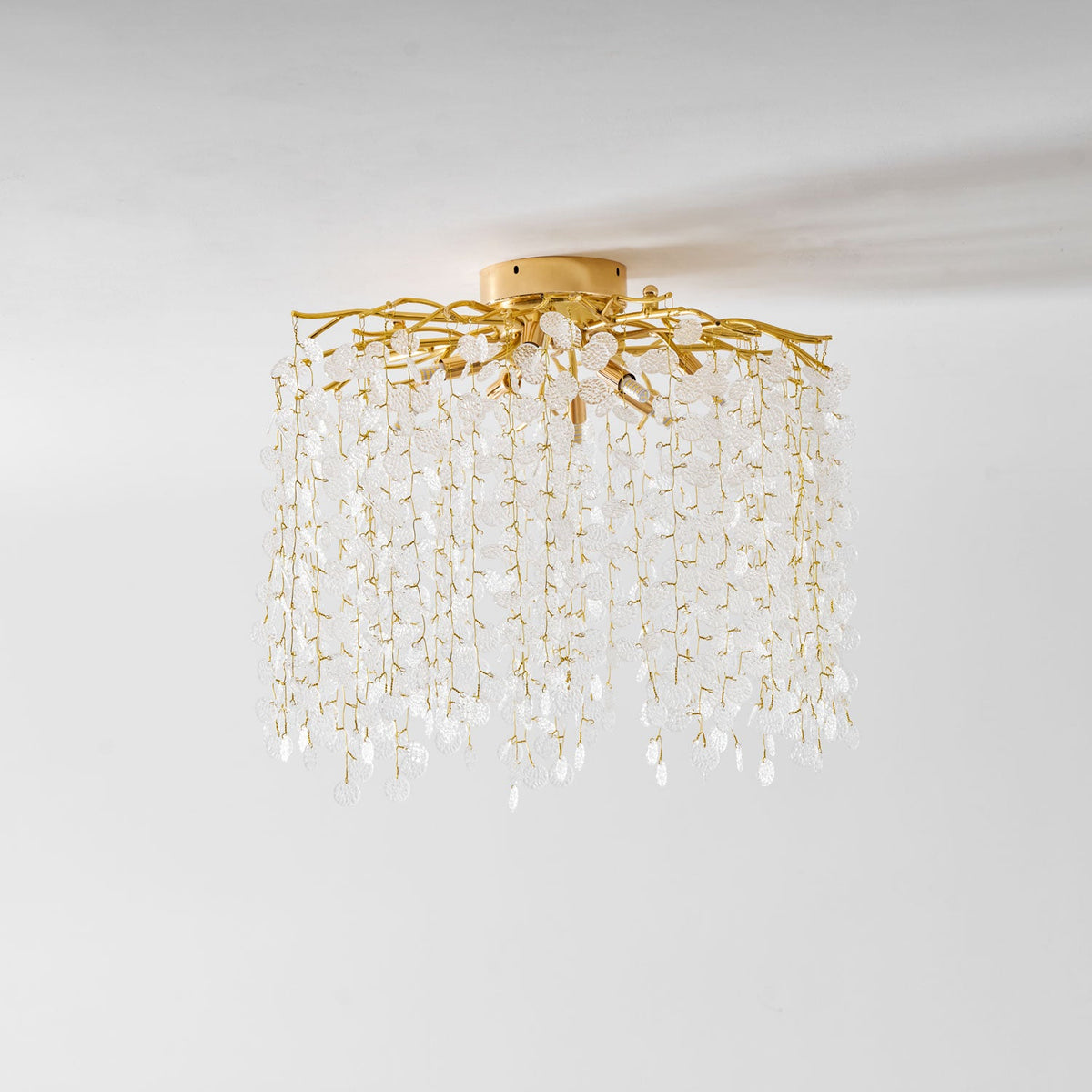 Viewed from below on a plain white background, this Clérachic ceiling light shows its mounting plate and gold branches.