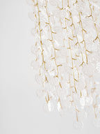 Close view of the gold branches and frosted glass discs cascading from this Clérachic ceiling light.