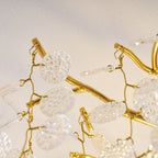 Extreme close view of the gold branches and clear glass discs on this Clérachic ceiling light, backlit in warm light.