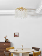Near a small framed print, this Clérachic ceiling light hangs above a round dining table set with a teacup and candle holder.