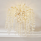 Seen from an angle, this Clérachic ceiling light cascades from a wall-ceiling corner, its frosted glass discs catching the light on gold branches.