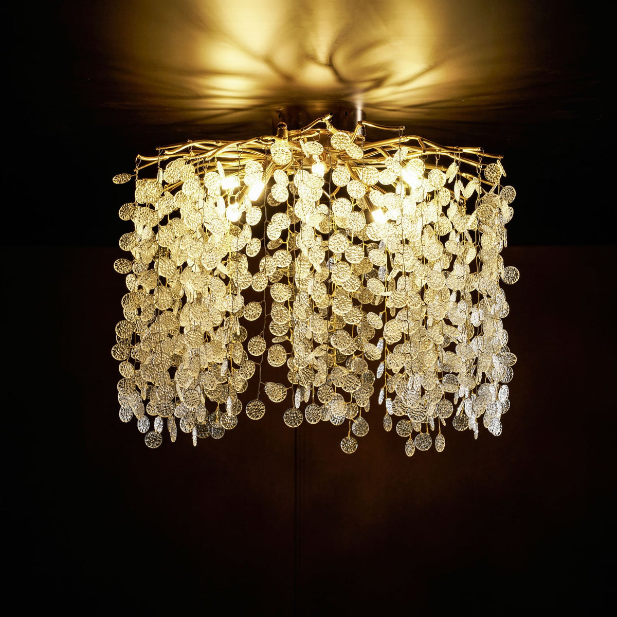 Glowing gold in a dark room, this Clérachic ceiling light's frosted glass discs catch the warm light up close.