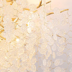 Close view of the frosted glass discs and gold branches on this Clérachic ceiling light, lit from within.