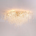 Lit against a plain grey backdrop, this Clérachic ceiling light's frosted glass discs glow warm above its gold branches.