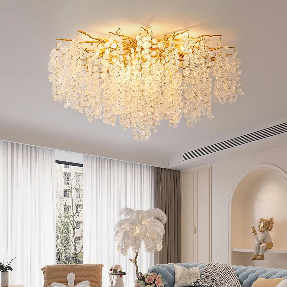 Lit above a living room seating area, this Clérachic ceiling light glows softly through frosted glass discs on gold branches, beside sheer curtains.