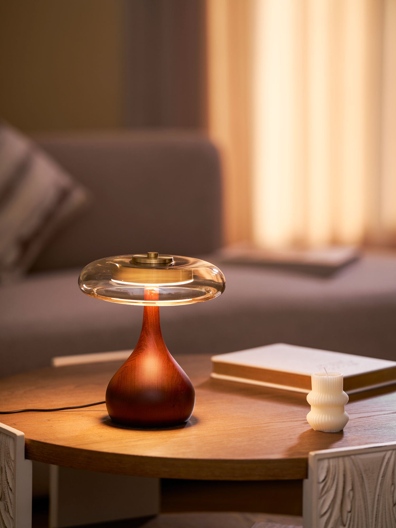 Amber glass table lamp glowing gently on a wooden surface