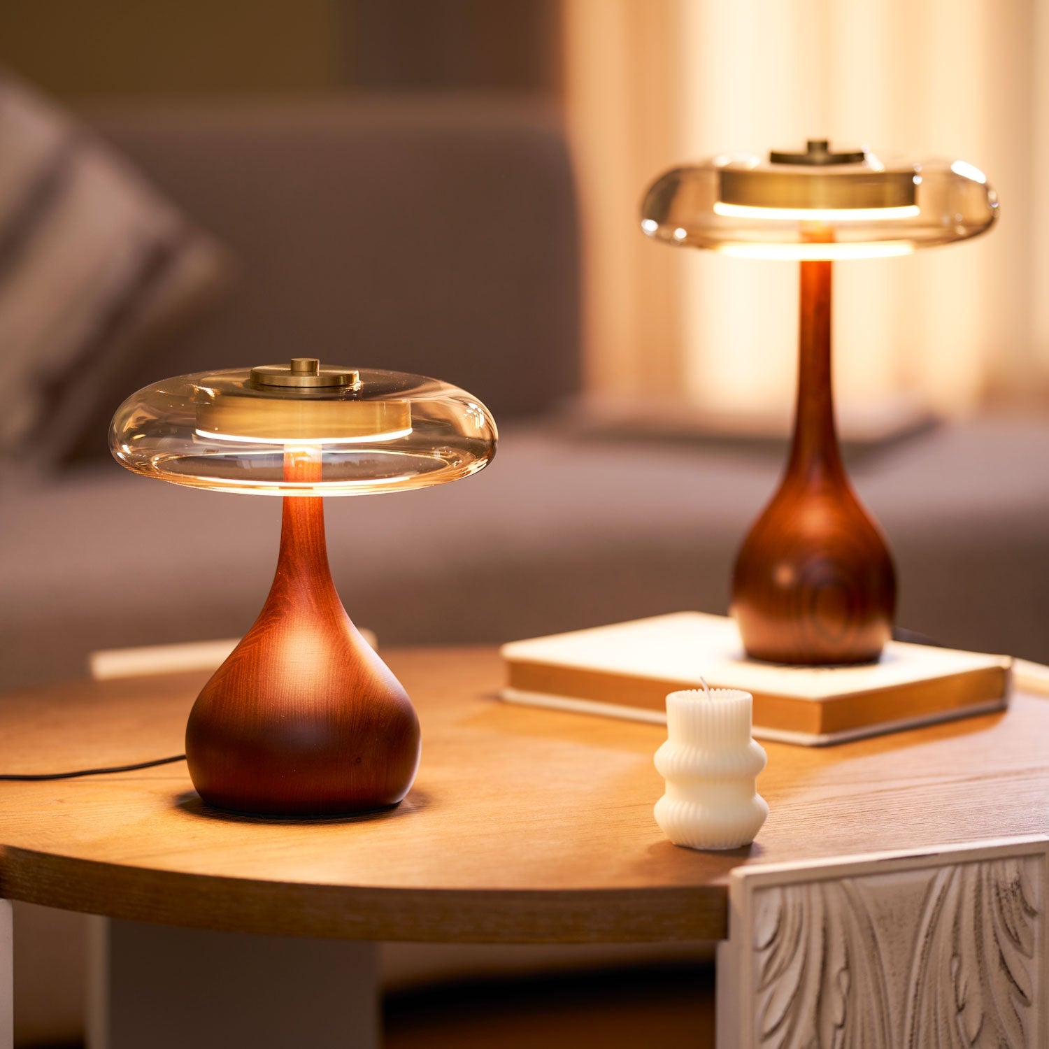 Walnut base table lamp lit softly beside a cozy chair