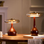 Amber glass table lamp shown beside books on a desk