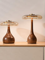 Wood table lamp with amber shade glowing on a bedside table