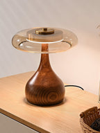 Walnut table lamp casting a golden amber glow in a bedroom