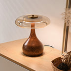 Walnut table lamp with amber glass glowing in soft light