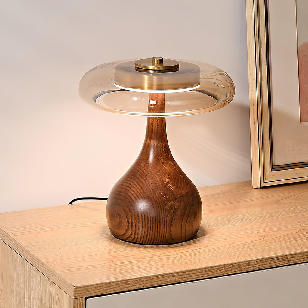 Wood table lamp with amber shade shown on a side table