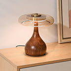 Wood table lamp with amber shade shown on a side table