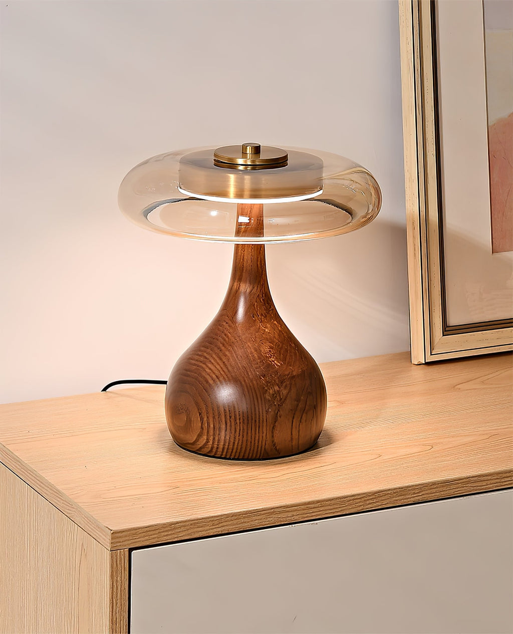 Curved wood base table lamp with amber shade in warm tones