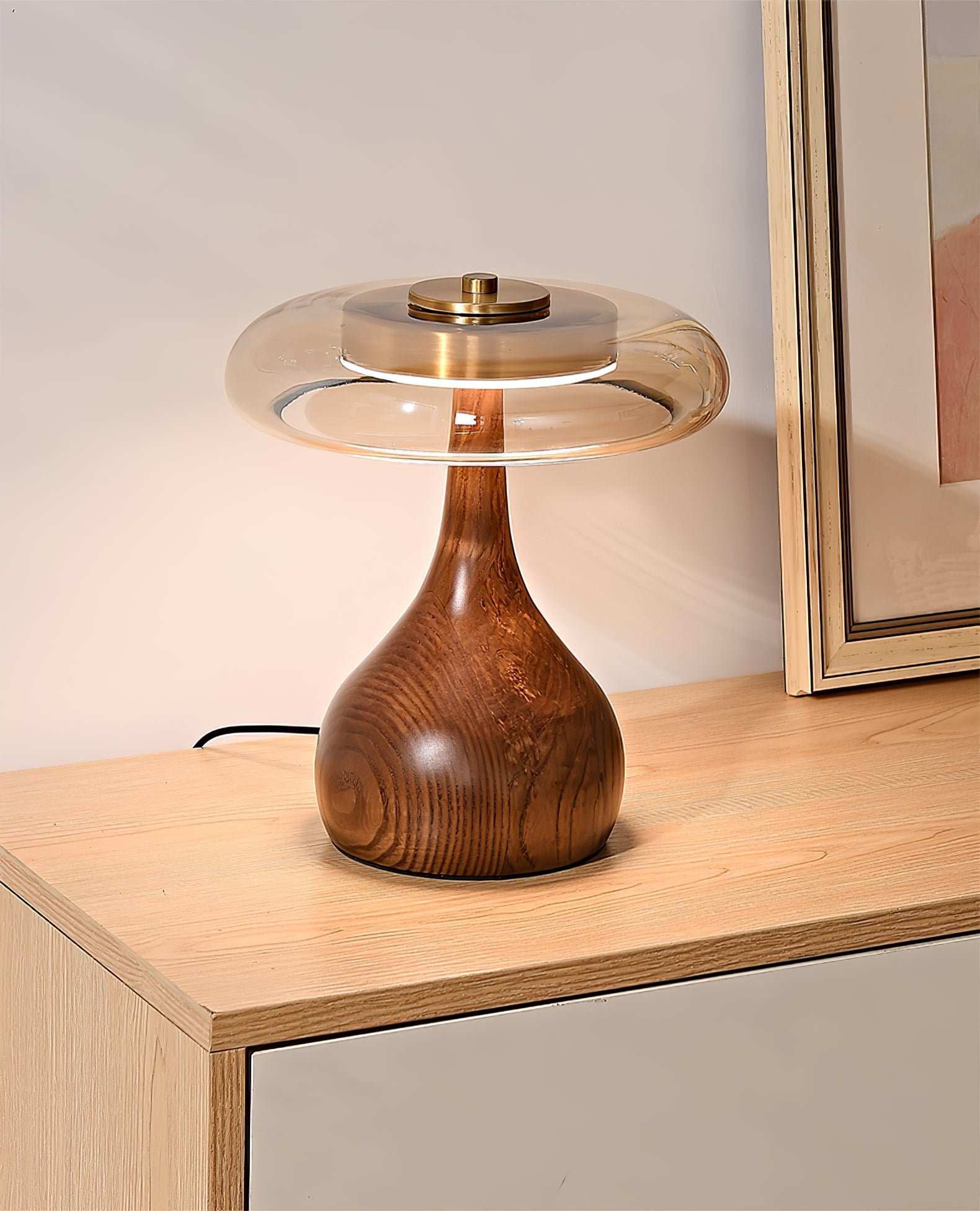 Curved wood base table lamp with amber shade in warm tones