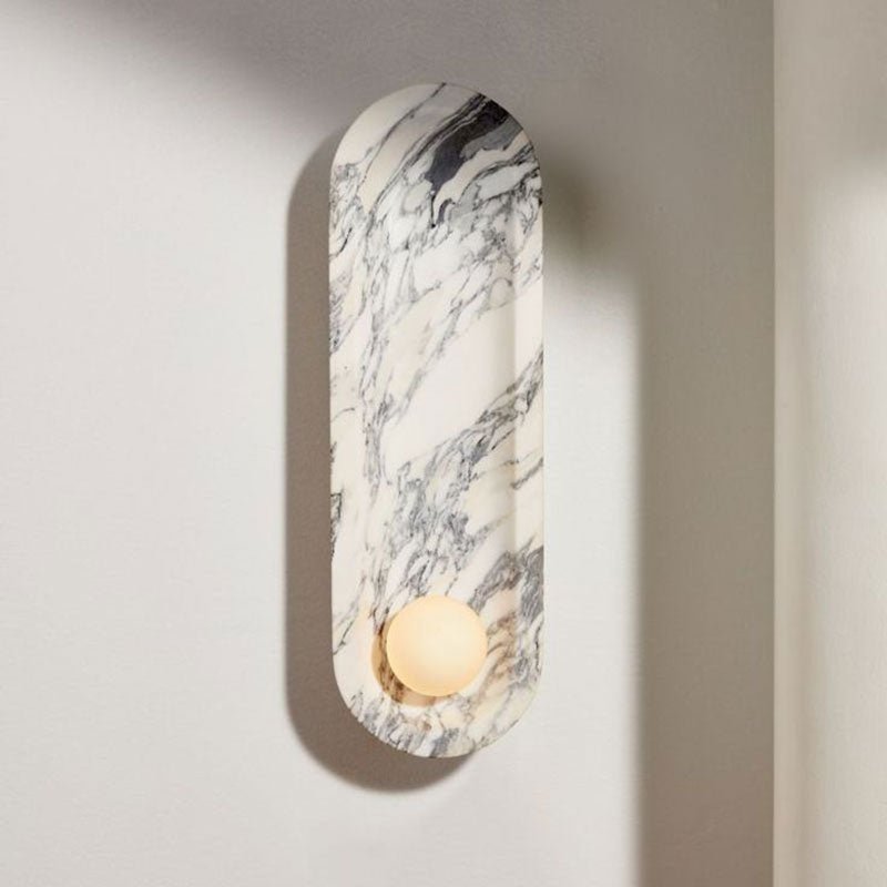 Natural light falls across the Clérachic wall sconce, its opal sphere unlit and its marble veining cast in shadow.