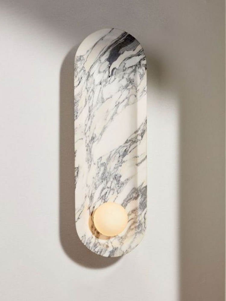 A side-angled, unlit view of the Clérachic wall light shows the depth of its curved marble niche on the wall.