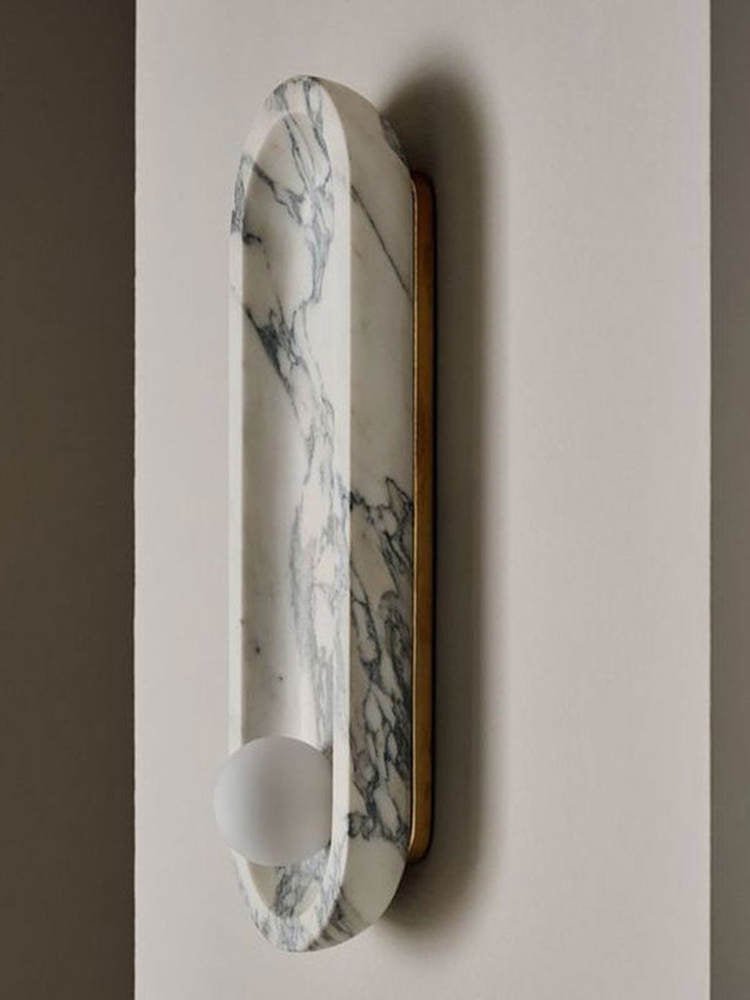This close view of the Clérachic wall light shows the brass backplate holding its marble form flush to the wall.