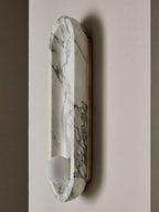 This close view of the Clérachic wall light shows the brass backplate holding its marble form flush to the wall.
