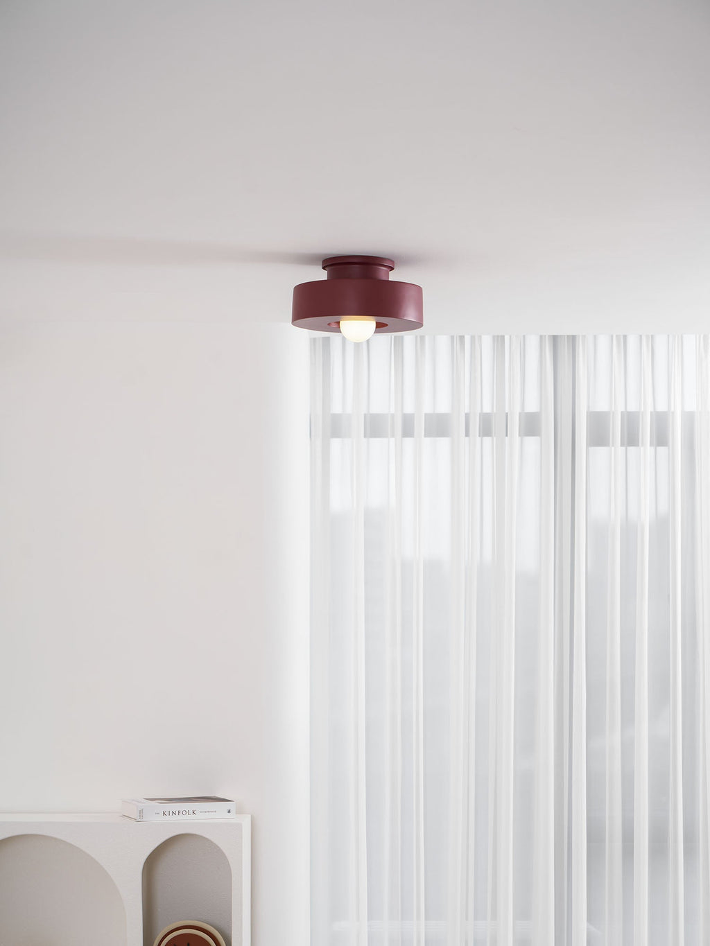 Sculptural resin ceiling light shown in red, green and black
