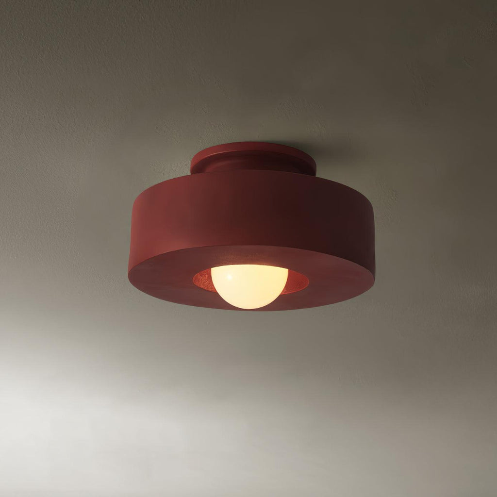 Stacked cylinder ceiling light glowing warmly above a space