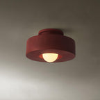 Stacked cylinder ceiling light glowing warmly above a space