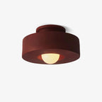 Resin ceiling light with stacked forms against a light ceiling