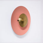 Side profile of a salmon-pink Clérachic wall light on white, showing its antique copper centre in depth.