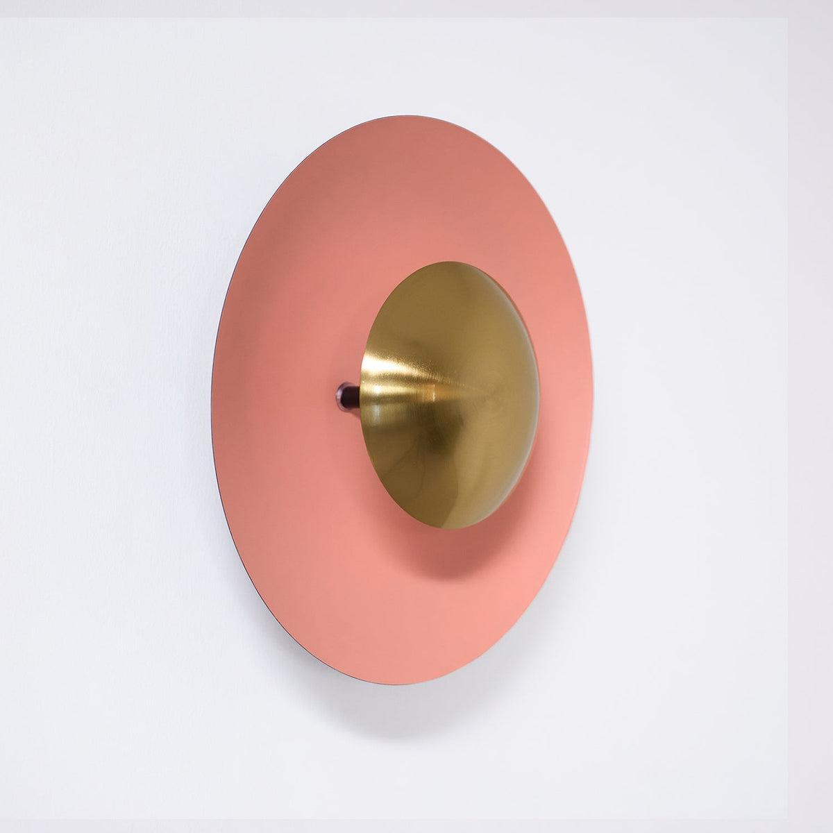 Side profile of a salmon-pink Clérachic wall light on white, showing its antique copper centre in depth.