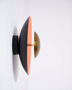 Side view of this Clérachic wall light on a white wall, showing its black mount arm and the slim edge of its shade.