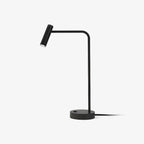 Studio shot of this black Clérachic table lamp, unlit, its cord curling from a round base.