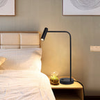 Checked bedding dresses the bed beside this black Clérachic table lamp, lit, on a wood nightstand.