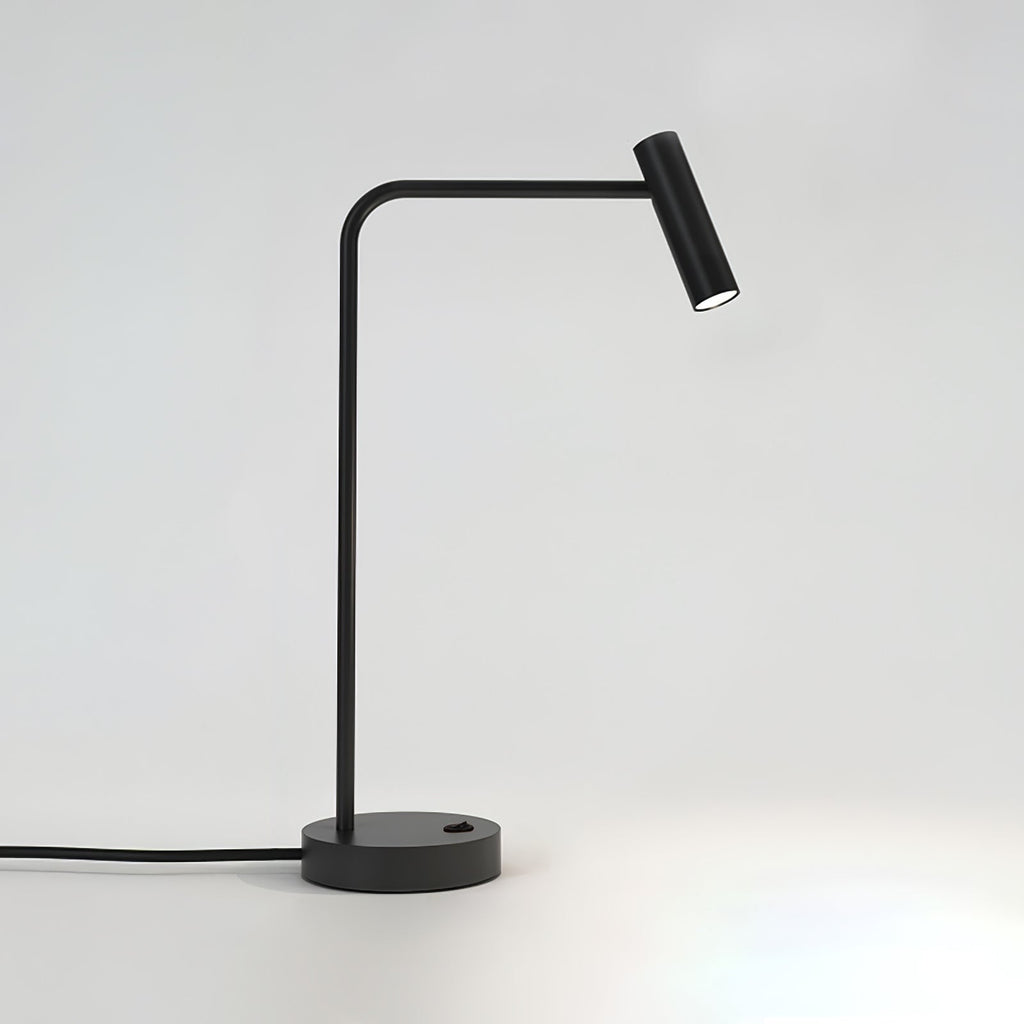 Cord curling from its round base, this black Clérachic table lamp stands unlit in the studio.