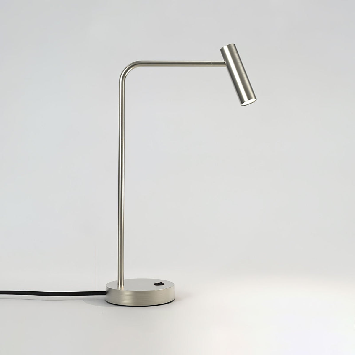Angled studio view of this sand nickel Clérachic table lamp, unlit, head turned toward the light.