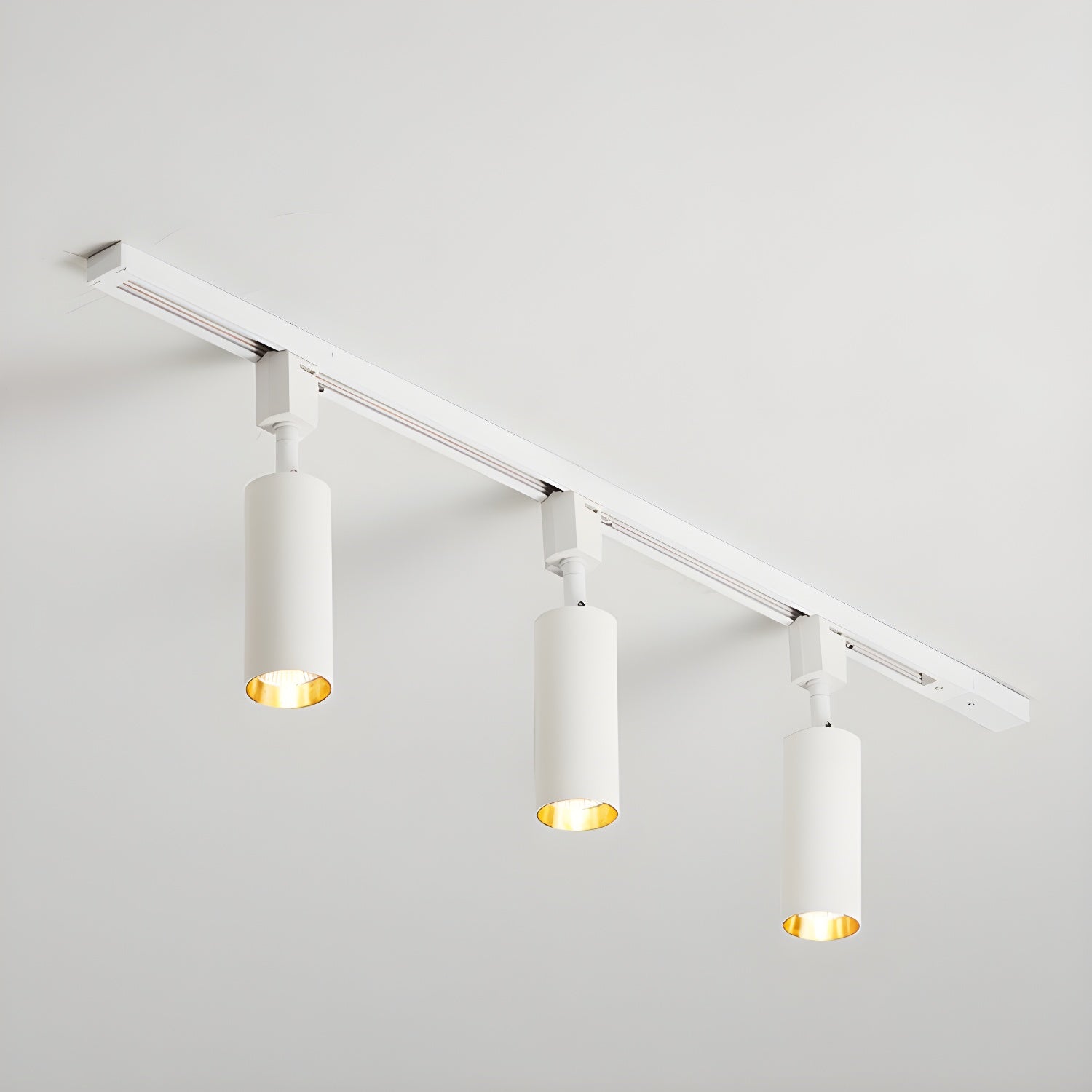 Track light with aluminium cylinders lighting a display area