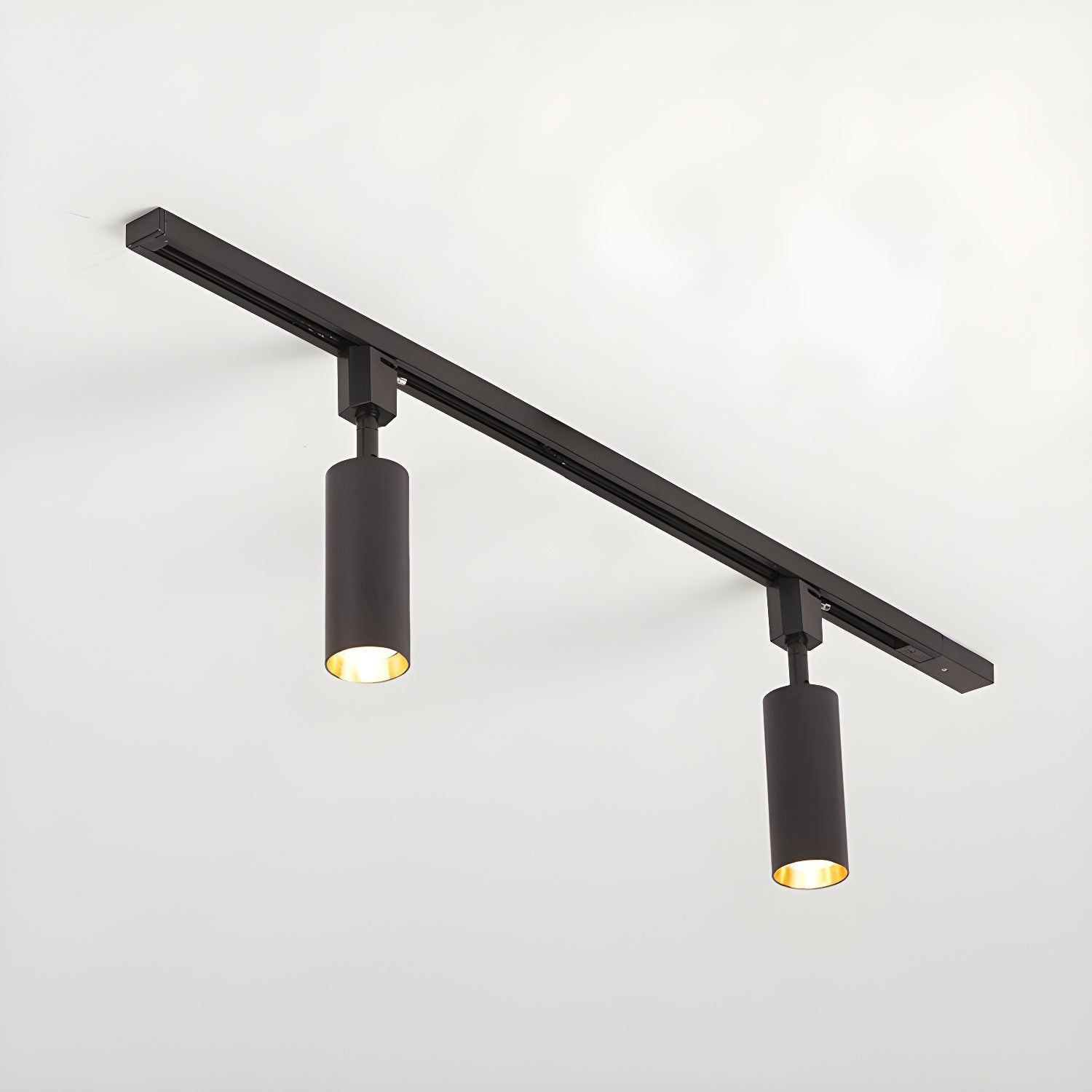 Cylinder spotlights on a track highlighting artwork below