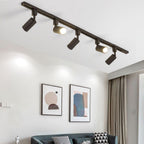 Track light cylinders casting focused light on a wall