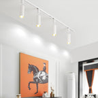 White cylinder track light spotlights on a ceiling rail
