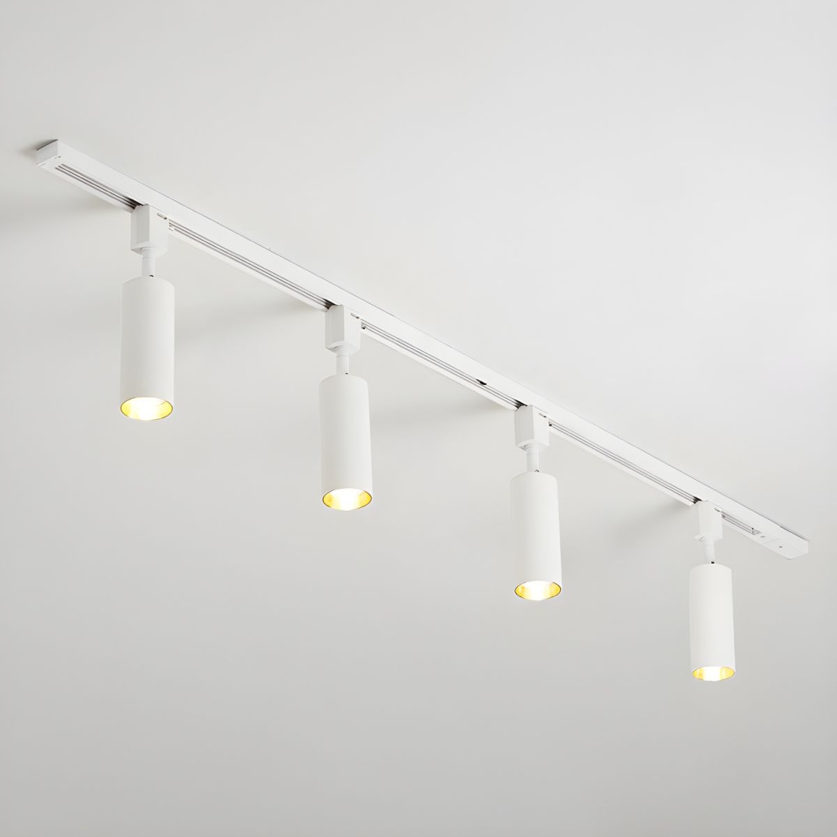Track light with black cylinder heads mounted overhead