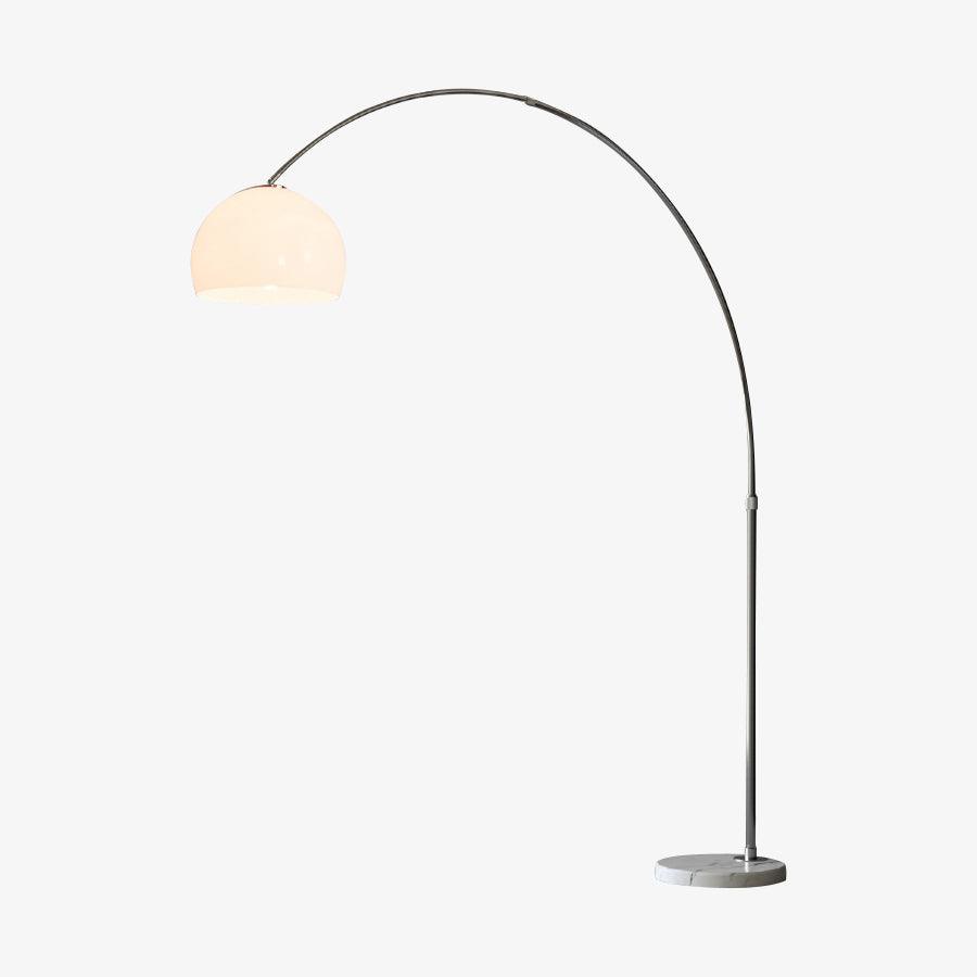 The slender steel arch of this Clérachic floor lamp rises straight from a round marble plinth to a matte white dome shade, shown unlit on white.