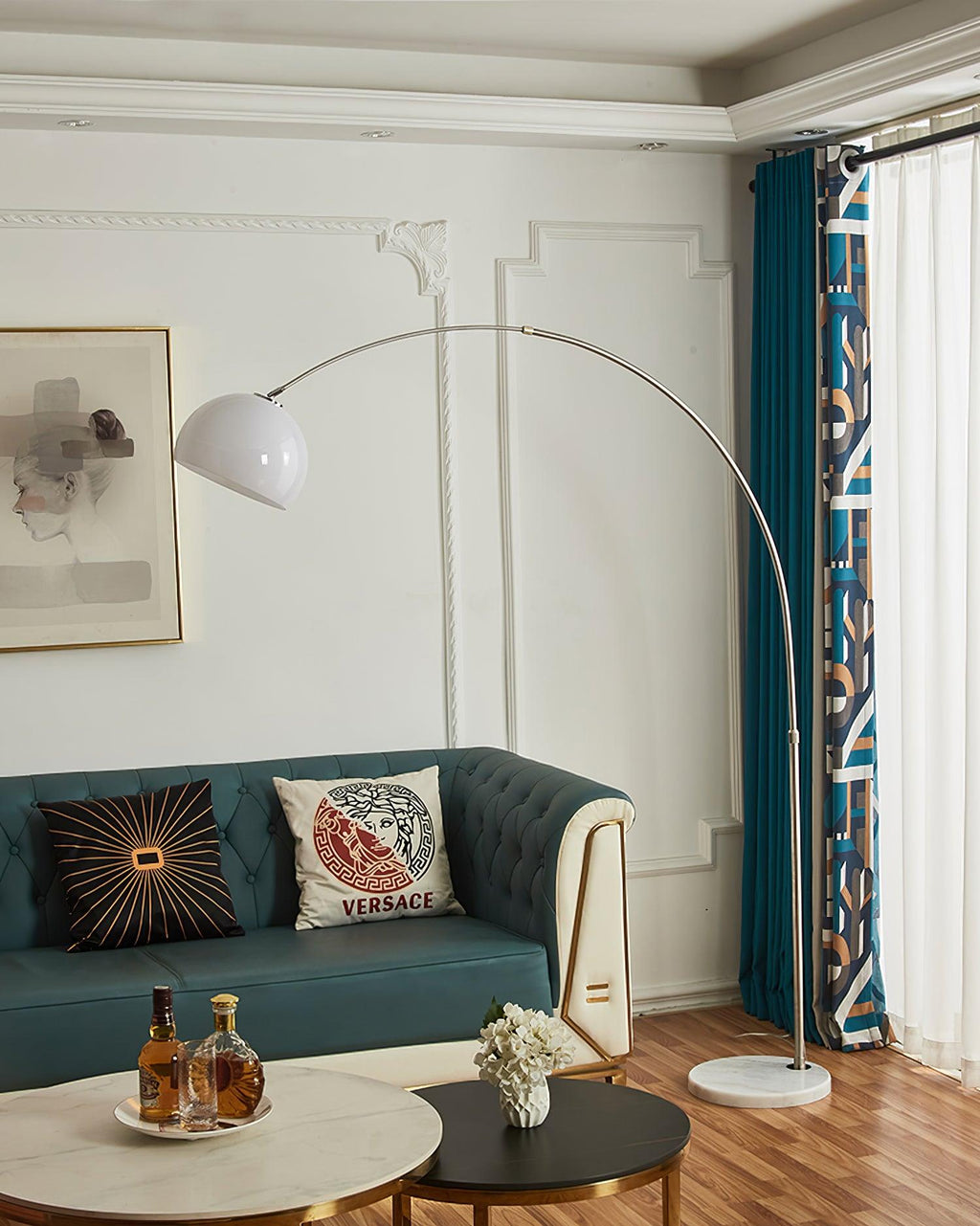 A close crop on the coffee table's whiskey tray sits beneath the Clérachic arc floor lamp's white dome shade over the teal sofa.