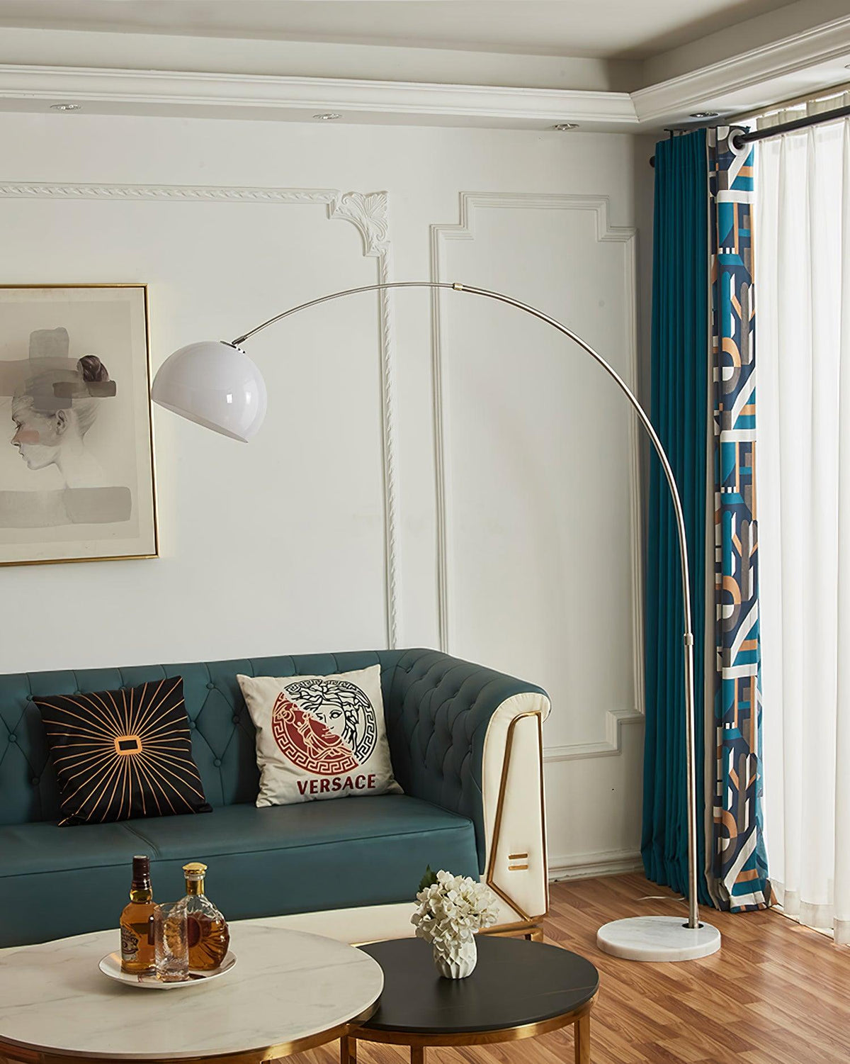 A close crop on the coffee table's whiskey tray sits beneath the Clérachic arc floor lamp's white dome shade over the teal sofa.