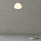 Photographed straight-on against a grey backdrop, the Clérachic arc floor lamp's white dome shade shows its full arc.