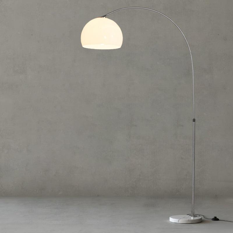 Photographed straight-on against a grey backdrop, the Clérachic arc floor lamp's white dome shade shows its full arc.