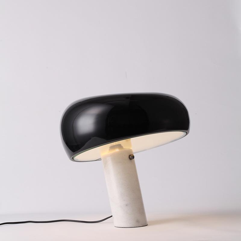 Carrara marble table lamp lit warm on a sideboard