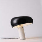 Carrara marble table lamp lit warm on a sideboard