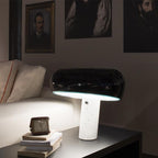 Carrara marble table lamp glowing on a nightstand