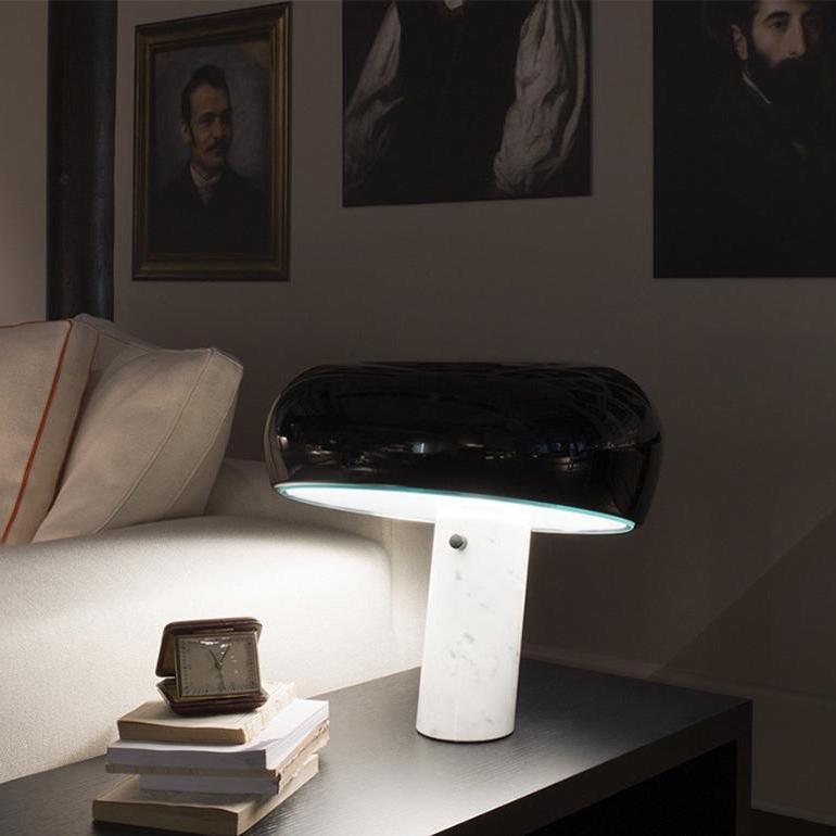Carrara marble table lamp glowing on a nightstand