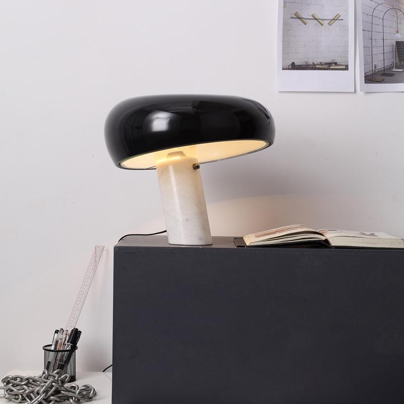 Marble table lamp glowing warm with a metal shade