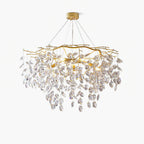The round chandelier on white, layered crystal petals catching light beneath the brass branches.